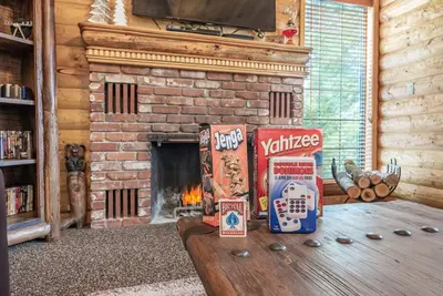 a living room with a fireplace and a table with snacks at The Stew Cabin Cozy Escape Fireside Memories in Shaver Lake