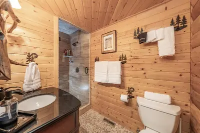 a log cabin bathroom with a sink and a toilet at The Stew Cabin Cozy Escape Fireside Memories in Shaver Lake