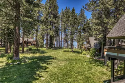 a yard with trees and a house at Chambers Lakeside Escape w Lake Views & HOA Access! in Homewood