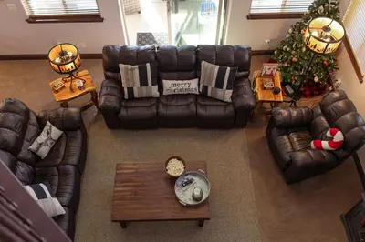 a living room with leather furniture and a christmas tree at The Chalet at Shaver Lake We Have it ALL! in Shaver Lake