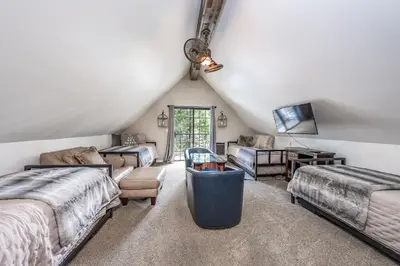 a attic bedroom with two beds and a tv at Ridgeview Retreat Location Meets Comfort AC! in Shaver Lake
