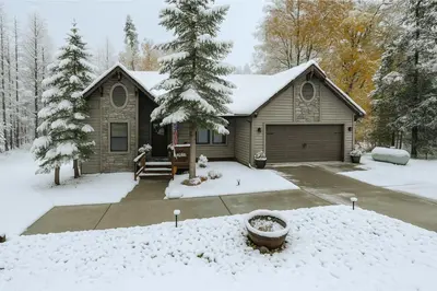 a house covered in snow with a yard at Creekside Cabin - Pup-Friendly with AC in Shaver Lake