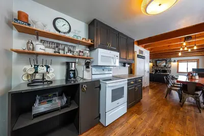a kitchen with white appliances and a dining room at The Elderberry Retreat - It's a Dream Location! in Shaver Lake