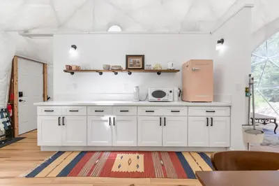 a kitchen with white cabinets and a microwave at Dome Sweet Dome | Shaver Lake in Shaver Lake