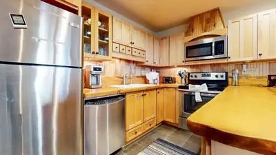 a kitchen with wooden cabinets and a stainless steel refrigerator at Lakeview Villas #09 condo in Mammoth Lakes