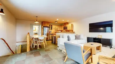 a living room with a white couch and a kitchen at Lakeview Villas #09 condo in Mammoth Lakes