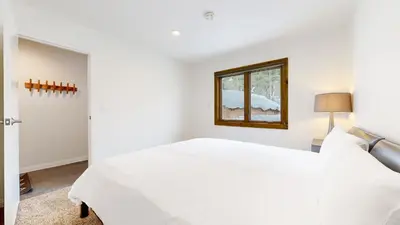 a white bedroom with a bed and a window at Lakeview Villas #09 condo in Mammoth Lakes