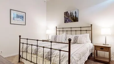 a bedroom with a bed and two lamps on a table at Summit #48 condo in Mammoth Lakes