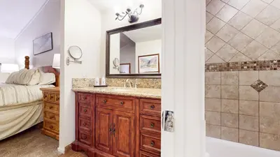 a bathroom with a sink and a mirror and a bed at Summit #48 condo in Mammoth Lakes