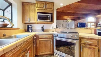 a kitchen with wooden cabinets and a sink and a stove at Snowflower #75 condo in Mammoth Lakes