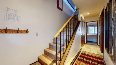 a staircase in a house with wooden rails and a stair case at Snowflower #75 condo in Mammoth Lakes