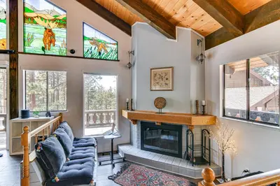 a living room with a fireplace and stained glass windows at Near Skiing and Beach Access South Lake Tahoe Cabin in South Lake Tahoe