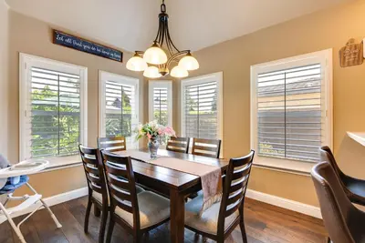 a dining room with a table and chairs and windows at Clovis Retreat with Patio and Yard about 3 Mi to Old Town! in Clovis