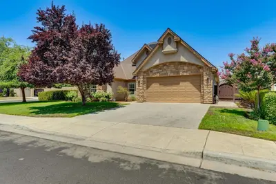 a house with a garage on a driveway at Clovis Retreat with Patio and Yard about 3 Mi to Old Town! in Clovis