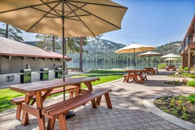 a group of picnic tables with umbrellas and a lake at Spacious 1br Condo w/Partial Lake View #117 at Donner Lake Village in Truckee