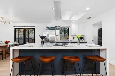 a kitchen with a large island with bar stools at Secluded Mtn Top Family Haven with Spa, Views & Arcade in Oakhurst