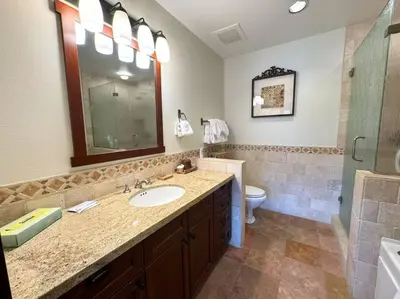 a bathroom with a sink and a toilet and a mirror at Luxury Townhome w/ Views, Private Jacuzzi & Garage in Mammoth Lakes