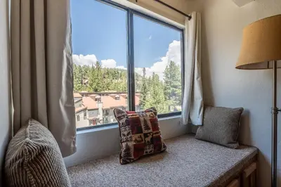a window seat with a pillow and a window with a view at Courchevel #15 - 2 Bedroom, 2 Bathroom, Sleeps 6! Just steps to Canyon Lodge! in Mammoth Lakes
