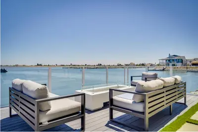 two chairs and a table on a deck overlooking the water at Waterfront Resort Style Villa - 5 min to fastwater in Oakley