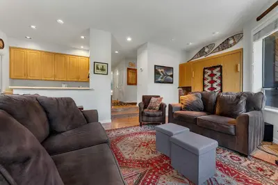 a living room with two couches and a rug at Palisades Condo - Walk to Ski Lift! in Olympic Valley