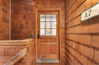 a door in a wooden wall with a sign on it at Palisades Condo - Walk to Ski Lift! in Olympic Valley