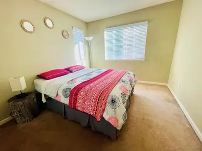 a bedroom with a bed with red pillows and a window at Cheerful & Spacious house to relax and unwind in Tracy