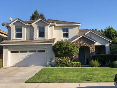 a house with a garage in front of it at Cheerful & Spacious house to relax and unwind in Tracy