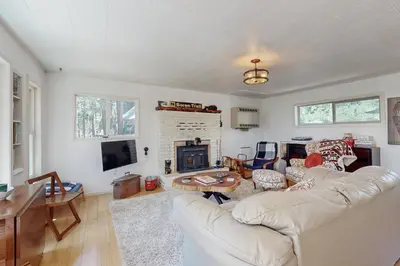 a living room with a white couch and a fireplace at 10 Mi to Bear Valley Resort Serene Mtn Retreat in Tamarack