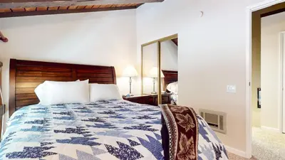 a bedroom with a bed and a mirror at Mammoth Ski & Racquet Club #118 condo in Mammoth Lakes