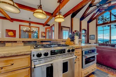 a kitchen with a stove and some windows at Lakefront Retreat Across from Homewood Resort in Homewood
