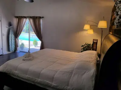 a bedroom with a bed and a large window at 3 Bedrooms,Beautiful House with Hot Tub, Pool Oasis and Fire Pit in Clovis