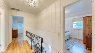a white room with a staircase and a bedroom at West Shore Lake House by AvantStay Ski Cabin w Backyard Sledding Hill in Homewood