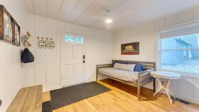 a bedroom with a bed and a window and a table at West Shore Lake House by AvantStay Ski Cabin w Backyard Sledding Hill in Homewood