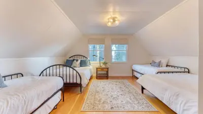 a attic room with three beds and a window at West Shore Lake House by AvantStay Ski Cabin w Backyard Sledding Hill in Homewood