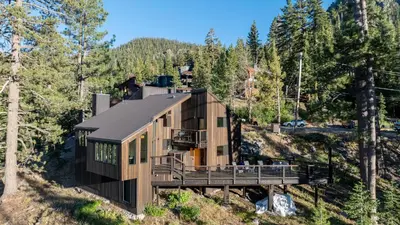 a house on the side of a hill with trees at Trapper by AvantStay A Interior Design w Sauna in Alpine Meadows