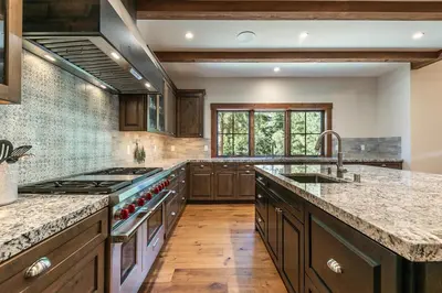 a large kitchen with wooden cabinets and a stove at Arcadia Manor on the West Shore - Newly Built - 5 BR w Wet Bar EV Charger and Air Conditioning in Tahoe City