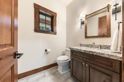 a bathroom with a toilet and a sink and a mirror at Arcadia Manor on the West Shore - Newly Built - 5 BR w Wet Bar EV Charger and Air Conditioning in Tahoe City