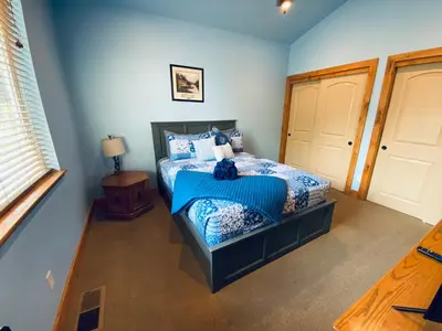 a bedroom with a bed with a blue comforter at The Hilltop Cabin Retreat in Bass Lake Heights in Oakhurst