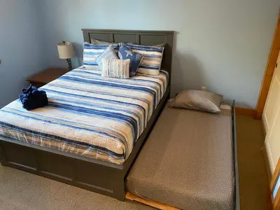 a bed with a blue and white striped comforter at The Hilltop Cabin Retreat in Bass Lake Heights in Oakhurst