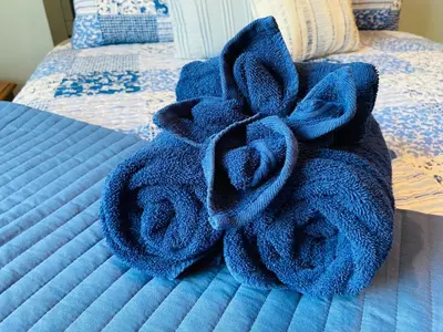 a pile of towels sitting on top of a bed at The Hilltop Cabin Retreat in Bass Lake Heights in Oakhurst