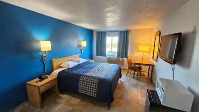a hotel room with a bed and a television at MetroParc 'nSuites in Stockton