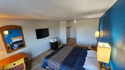 a hotel room with a bed and a mirror at MetroParc 'nSuites in Stockton