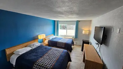 a hotel room with two beds and a flat screen tv at MetroParc 'nSuites in Stockton