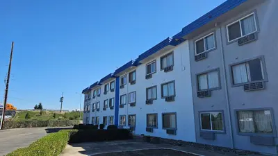 a large white building with windows on a street at MetroParc 'nSuites in Stockton