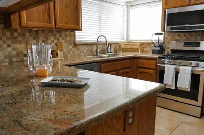 a kitchen with a counter top with wine glasses on it at Fernwood Retreat at Madera Ranchos in Madera