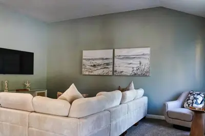 a living room with a white couch and three paintings at Fernwood Retreat at Madera Ranchos in Madera