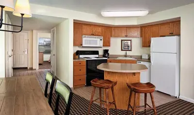 a kitchen with a table and a white refrigerator at WorldMark Angels Camp - 2BD in Angels Camp
