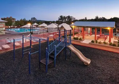 a playground with a slide in front of a pool at WorldMark Angels Camp - 2BD in Angels Camp