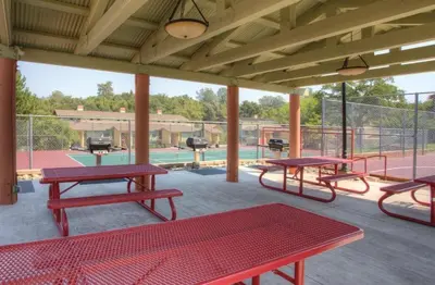 a patio with red picnic tables and a pool at WorldMark Angels Camp - 2BD in Angels Camp