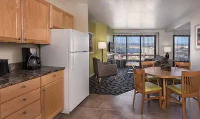 a kitchen with a refrigerator and a table with chairs at Enjoy all Reno has to offer in this 2BD resort condo with outdoor pool or hot tub in Reno